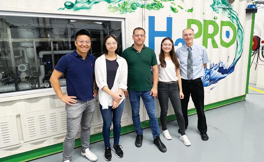 Photo taken with personnel of the customer, an Israeli manufacturer of hydrogen production systems. Behind them is a hydrogen production system. (Hagihara is second from the right.)