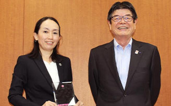 Ms. Kunii with her plaque and souvenir brooch