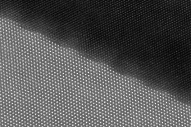 This is an atomic resolution image of the crystal interface of a cutting tool material observed by Scanning Transmission Electron Microscope (STEM). Periodic distortion is observed at the interface.