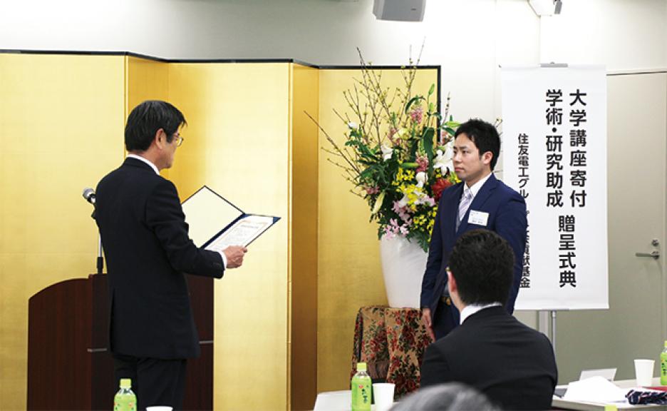 President Osamu Inoue presenting a catalog